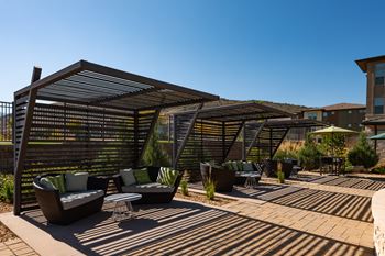 A patio with a table and chairs under a pergola.